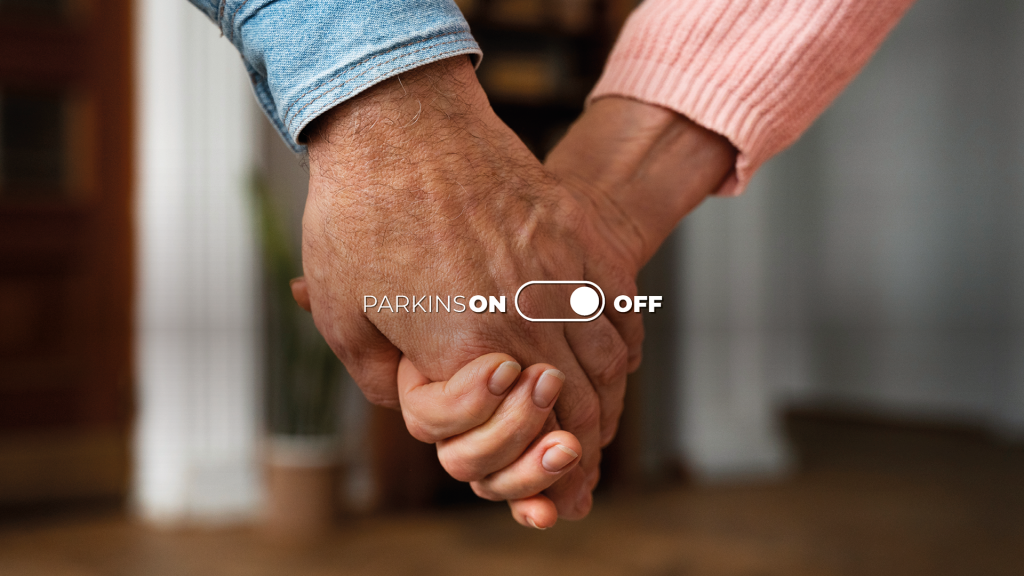Due persone si tengono per mano nella campagna Parkinson OFF